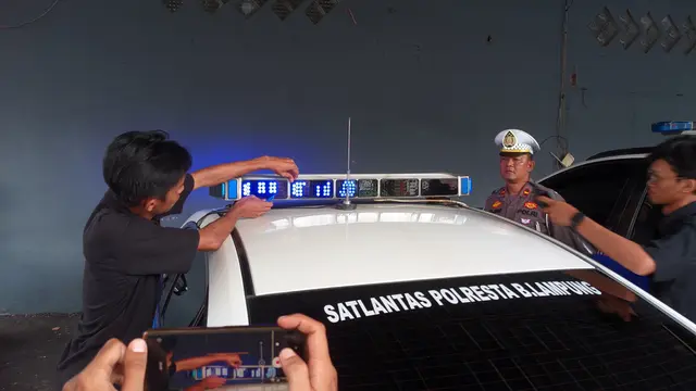 Pemasangan kaca film pada lampu rotator mobil Satlantas Polresta Bandar Lampung. Foto : (Liputan6.com/Ardi)