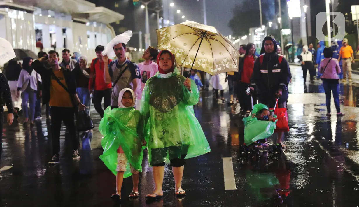 Masyarakat mulai memadati car free night di kawasan Thamrin, Jakarta, Selasa (31/12/2019). Meski diguyur hujan masyarakat mulai memadati kawasan tersebut untuk menikmati malam pergantian tahun 2019. (Liputan6.com/Angga Yuniar)