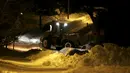 Alat berat digunakan untuk  membersihkan tumpukan salju di Silver Spring , Amerika Serikat (25/1/16). Badai ini menyebabkan kerugian miliaran dolar dan menewaskan lebih dari 30 orang. (REUTERS/Gary Cameron)
