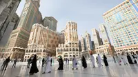 Jemaah tiba di Masjidil Haram pada awal musim haji di Mekkah, Arab Saudi, Sabtu (17/7/2021). Jemaah haji melakukan tawaf dengan tetap menjaga jarak demi mengantisipasi penyebaran COVID-19. (FAYEZ NURELDINE/AFP)