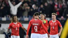 Haris Saferovic dan Granit Xhaka merayakan gol pertama timnas Swiss pada laga Nations League yang berlangsung di stadion Swiss porarena, Senin (19/11). Timnas Swiss menang 5-2. (AFP/Fabrice Coffrini)