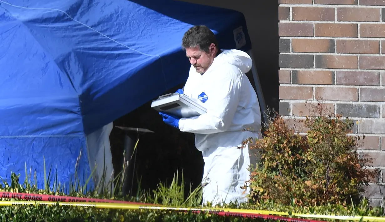 Seorang tim investigasi mengecek barang bukti di lokasi penembakan massal di Borderline Bar & Grill di Thousand di Thousand Oaks, California (8/11). Pelaku penembakan tewas dengan melakukan tembakan bunuh diri. (AFP Photo/Robyn Beck)