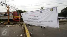 Kereta Commuter Line melintasi perlintasan sebidang di Pasar Minggu yang ditutup sementara, Jakarta, Selasa (9/5). Penutupan secara permanen akan dilakukan pada 2 Juni mendatang. (Liputan6.com/Helmi Fithriansyah)