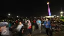 Pengunjung memadati halaman Monumen Nasional, Jakarta, Sabtu (31/12). Meski panggung hiburan malam pergantian tahun dibatalkan namun pengunjung tetap memadati kawasan Monumen Nasional . (Liputan6.com/Helmi Fithriansyah)