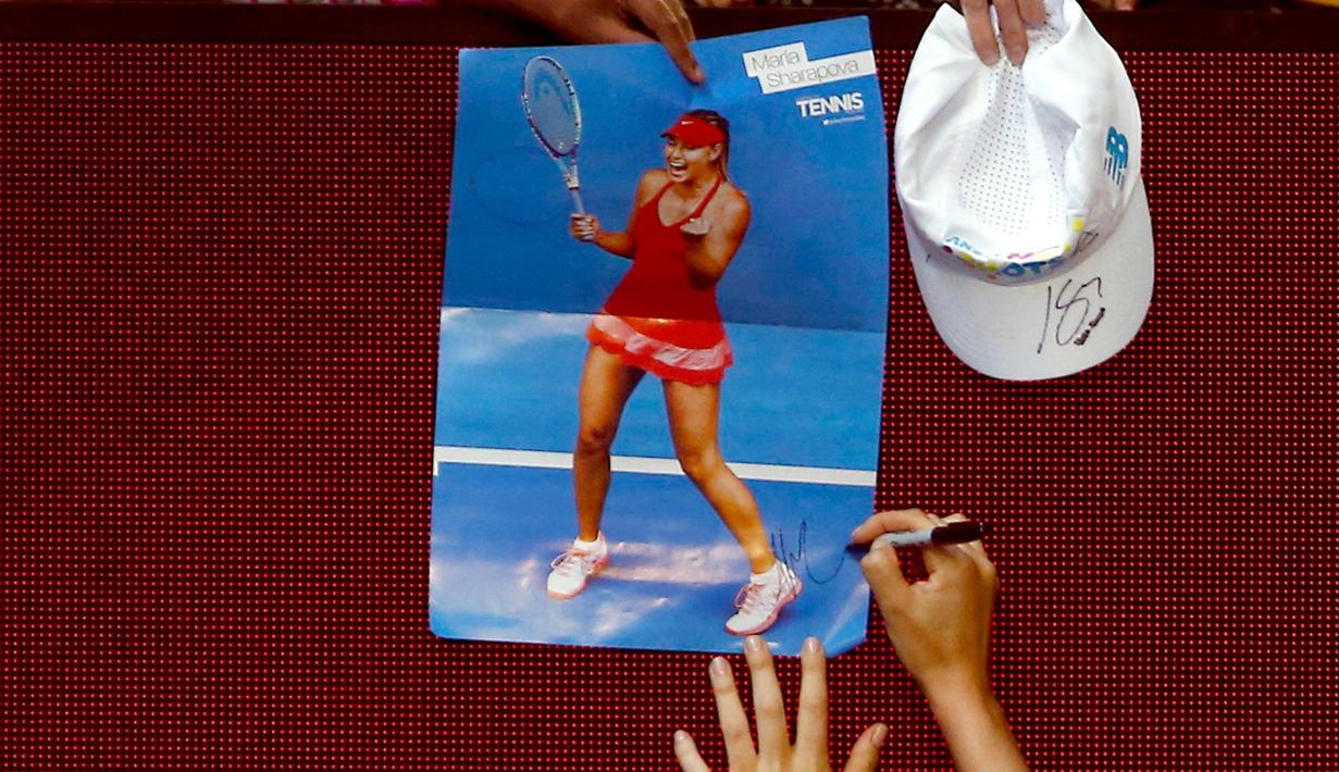 Maria Sharapova menandatangani poster bergambar dirinya usai memenangkan pertandingan ketiga putaran melawan Lauren Davis di turnamen Australia Open 2016 di Melbourne Park, Australia, (22/1). Sharapova menang 6-1, 6-7(5), dan 6-0. (REUTERS/Jason Reed)