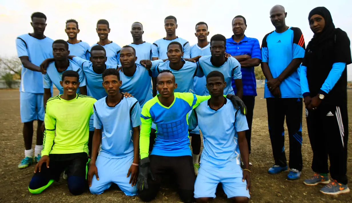 Salma al-Majidi berpose dengan pemain klub Al-Ahly Al-Gadaref setelah melatih sesi latihan di kota Gedaref, timur Khartoum (17/2). Di Sudan di mana tim sepak bola wanita nasional tidak berkembang. (AFP Photo/Ashraf Shazly)