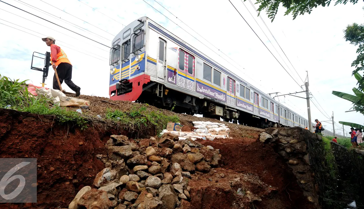 Pekerja meletakkan batuan untuk memperkuat struktur tanah yang longsor dekat rel KRL di sekitar Kampung Pabuaran, Bogor, Rabu (25/11/2015). Sebelumnya, Selasa (24/11) tanah di sekitar rel KM 38 dan 39 mengalami longsor. (Liputan6.com/Helmi Fithriansyah)