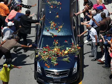 Sejumlah penggemar mengulurkan tangan untuk menyentuh mobil jenazah yang membawa jasad mantan petinju dunia, Muhammad Ali saat akan dimakamkan di Louisville, Kentucky, AS, 10 Juni 2016. (REUTERS/Adrees Latif )