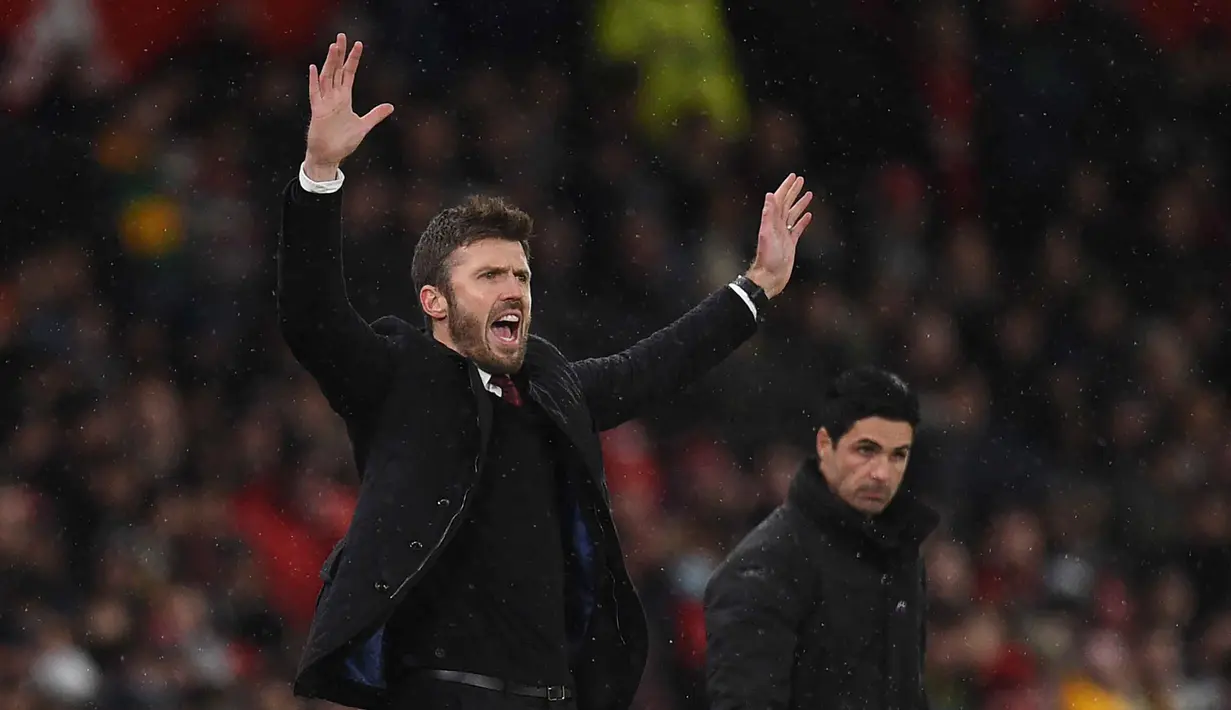 Setelah pensiun pada 2018, Michael Carrick bergabung sebagai staf pelatih The Red Devils, ia sempat menjabat sebagai pelatih sementara ketika Solskjaer tak lagi melatih MU. Tampak dalam foto, Michael Carrick saat masih menjadi pelatih sementara Manchester United memberi isyarat di pinggir lapangan selama pertandingan sepak bola Liga Premier Inggris melawan Arsenal di Old Trafford, Manchester, Inggris barat laut, pada 2 Desember 2021. (Oli SCARFF/AFP)