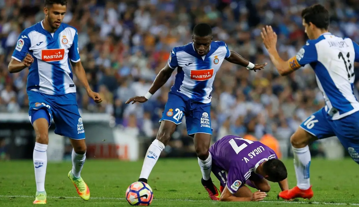 Pemain Real Madrid, Lucas Vazquez terjatuh saat berebut bola dengan pemain Espanyol pada laga La Liga 2016-2017 di Estadio Cornella-El Prat, Senin (19/9/2016) dini hari WIB. (AFP/Pau Barrena)
