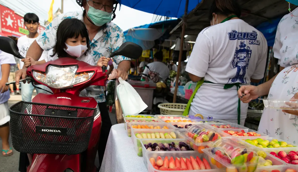 Orang-orang membeli manisan dalam Festival Vegetarian Phuket 2020 di Phuket, Thailand (20/10/2020). Festival ini tetap menjalankan kebijakan jaga jarak sosial (social distancing) ketat di tengah pandemi COVID-19 yang masih berlangsung. (Xinhua/Zhang Keren)