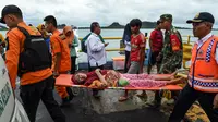 Anggota dari tim penyelamatan membawa seorang pengungsi lansia dengan tandu usai dievakuasi dari Pulau Sebesi di Pelabuhan Bakauheni, Lampung, Rabu (26/12). (AFP Photo/Mohd Rasfan)