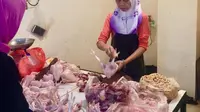 Pedagang ayam potong sedang melayani pembeli di tengah kenaikan harga jelang Idul Adha 2023. (Liputan6.com/Bam Sinulingga)