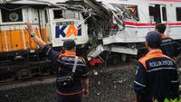 Para pekerja memeriksa kondisi lokomotif Kereta Api Jarak Jauh (KAJJ) Argo Bromo Anggrek dan salah satu gerbong Kereta Rel Listrik (KRL) Commuter Line yang mengalami kecelakaan di Stasiun Bekasi Timur, Bekasi, Jawa Barat, Selasa 28 April 2026. (AP Photo/Tatan Syuflana)