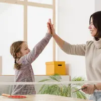 seorang ibu dan anak sedang melakukan high-five sambil tersenyum lebar/copyright&nbsp;freepik.com/freepik