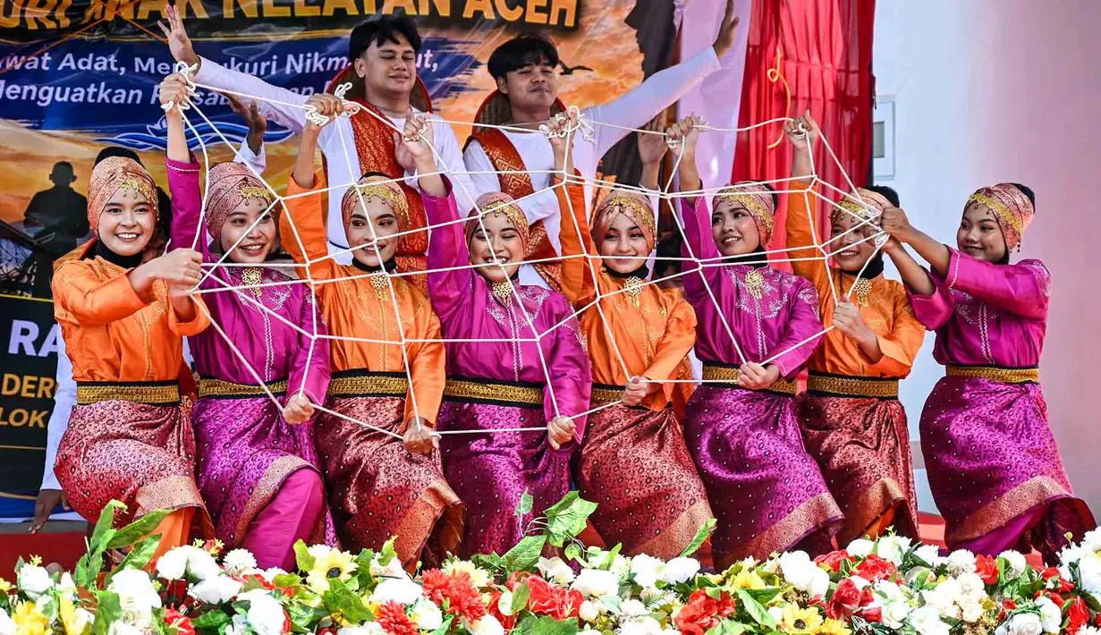 Seniman menampilkan tarian tradisional pesisir Rapai Geleng pada perayaan tradisi kenduri laut wilayah Panglima Laot Lok Kuala Cangkoi di Ulee Lheu, Banda Aceh, Aceh, Rabu (22/7/2026). (AFP/ Chaideer Mahyuddin).