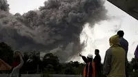 Sejumlah warga berkumpul melihat Gunung Sinabung yang tengah melontarkan awan panas di Desa Tiga Serangkai, Karo, Sumatera Utara, Rabu (24/6/2015). (REUTERS/Beawiharta)