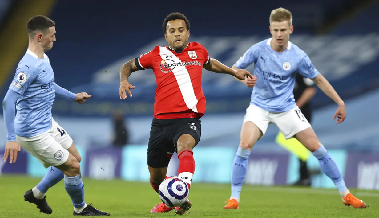 Pemain Manchester City Phil Foden (kiri) mencoba menghalau pemain Southampton Ryan Bertrand pada pertandingan Liga Inggris di Etihad Stadium, Manchester, Inggris, Rabu (10/3/2021). Manchester City menang 5-2. (Clive Brunskill/Pool via AP)