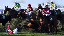 Seorang joki bernama Rachael Blackmore terguling ditanah saat mengikuti pacuan kuda Grand National di Aintree Racecourse di Liverpool, Inggris (14/4). Akibat insiden itu, Rachael Blackmore tidak dapat melanjutkan balapannya. (AFP/Paul Ellis)