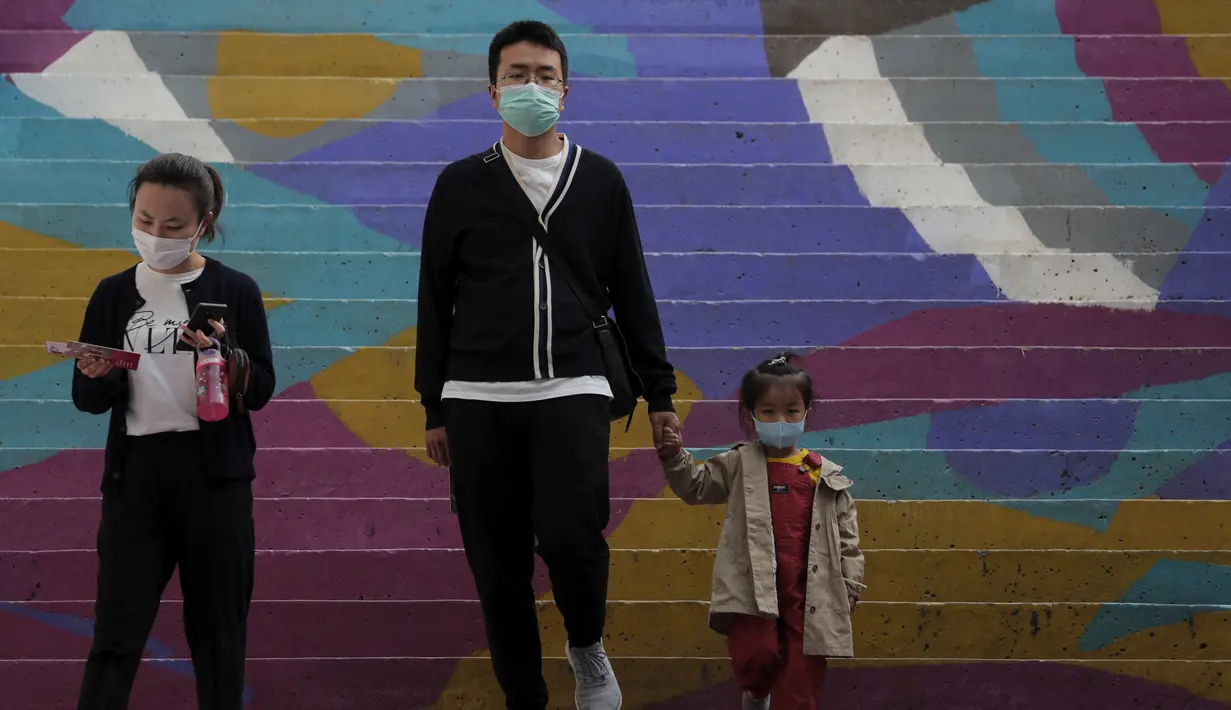 Sebuah keluarga mengenakan masker untuk mengekang penyebaran COVID-19 di Beijing, China, Minggu (11/10/2020). Meski penyebaran COVID-19 hampir diberantas di China, pandemi masih melonjak di seluruh dunia dengan jumlah kematian yang terus meningkat. (AP Photo/Andy Wong)