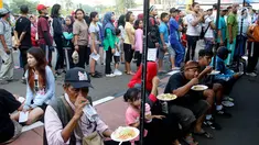 Warga memakan nasi goreng gratis ala prajurit Korps Marinir TNI AL saat car free day di Jakarta, Minggu (5/11). Kegiatan bagi-bagi nasi goreng ini dalam rangka menyambut HUT Marinir ke-72. (Liputan6.com/Angga Yuniar)