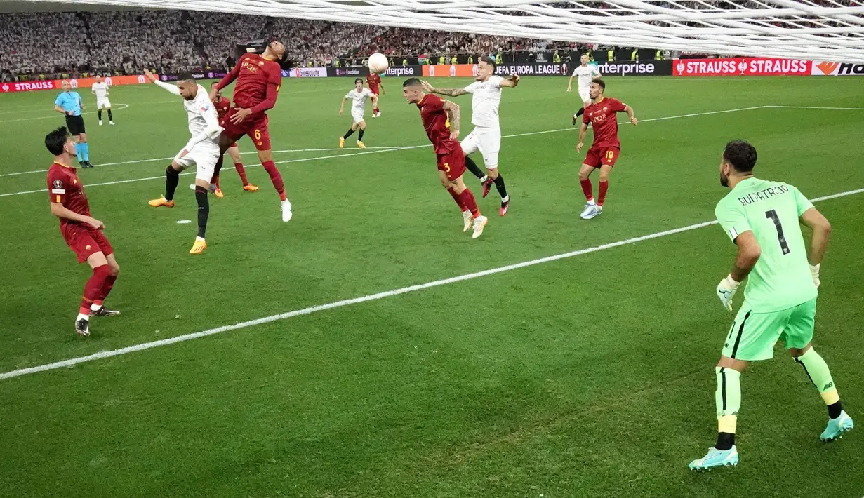 Pemain Sevilla, Lucas Ocampos (tiga kanan), berebut bola di udara dengan pemain AS Roma, Gianluca Mancini, dalam partai final Liga Europa 2022/2023 yang berlangsung di Puskas Arena, Budapest, Kamis (1/6/2023) dini hari WIB. (AFP/Pool/John Sibley)