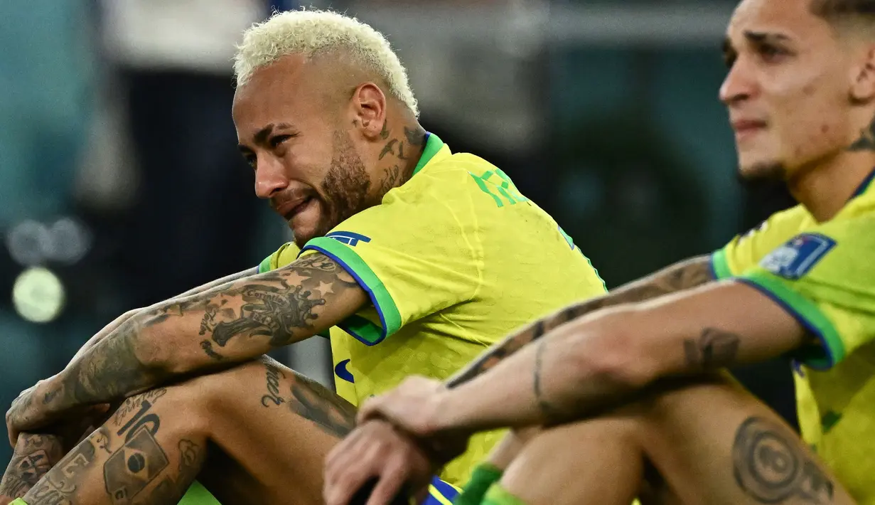 Pemain Brasil, Neymar (kiri) dan rekannnya, Antony menangis setelah tim mereka kalah dari Kroasia saat laga perempat final Piala Dunia Qatar 2022 yang berlangsung di Education City Stadium, Al-Rayyan, Jumat (09/12/2022) waktu setempat. Brasil kalah 2-4 dari Kroasia saat babak adu penalti. (AFP/Jewel Samad)