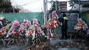 Seorang pekerja publik mengikat karangan bunga buatan dengan pesan-pesan dukungan untuk Presiden Korea Selatan yang dimakzulkan, Yoon Suk Yeol, di Seoul pada Kamis 9 Januari 2025. (Yasuyoshi CHIBA/AFP)