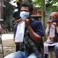 Warga meniupkan kantong saat menjalani tes deteksi COVID-19 dengan metode GeNose C19 usai terjaring razia penggunaan masker di Kelurahan Sudimara Barat, Kota Tangerang, Kamis (27/5/2021). Tes tersebut untuk menekan penyebaran corona di wilayah tersebut. (Liputan6.com/Angga Yuniar)