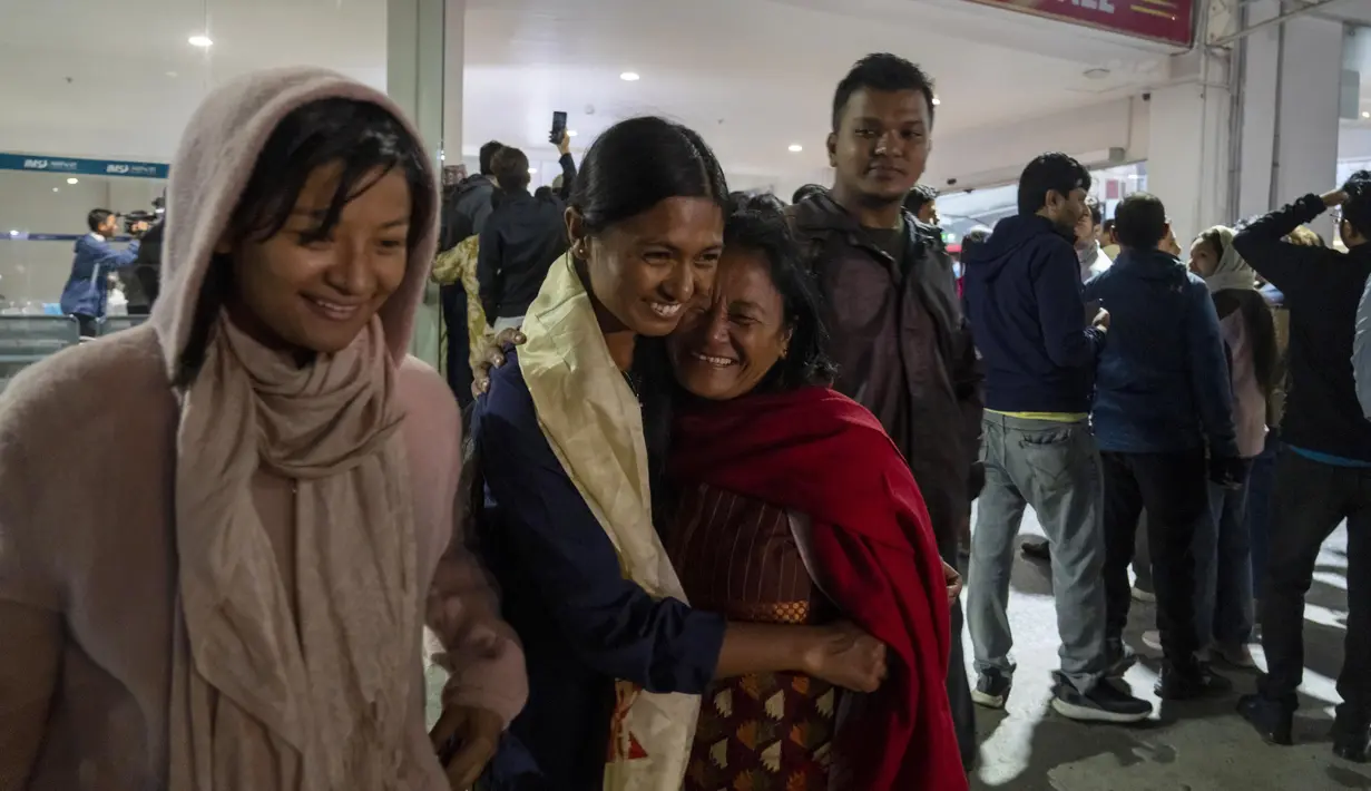 Seorang perempuan Nepal menyambut putrinya yang dievakuasi dari Israel di Bandara Internasional Tribhuvan di Kathmandu, Jumat, 13 Oktober 2023. (AP Photo/Niranjan Shrestha)