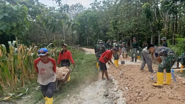 Anggota TNI dari Kodim 0721/Blora saat berjibaku bersama masyarakat dalam kegiatan TMMD ke-113 membangun jalan hutan menuju Dukuh Alas Malang, Desa Pengkoljagong, Kecamatan Jati, Kabupaten Blora. (Liputan6.com/Ahmad Adirin)