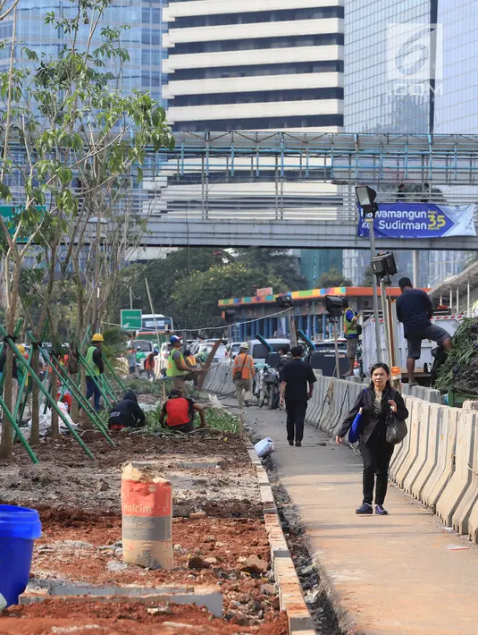 Pekerja menyelesaikan jalur pedestrian di Jalan Sudirman, Jakarta, Senin (2/7). Kelima stasiun tersebut yakni Stasiun Senayan, Stasiun Istora, Stasiun Bendungan Hilir, Stasiun Setiabudi dan Stasiun Dukuh Atas. (Liputan6.com/Arya Manggala)