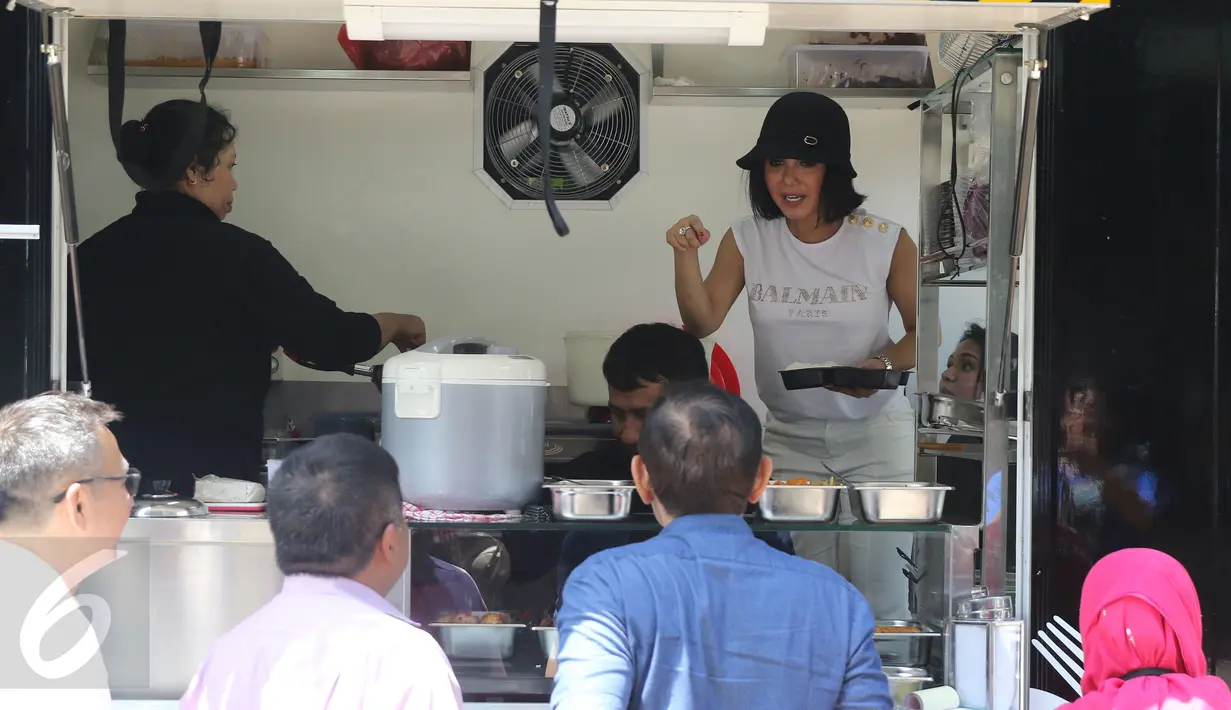 Penyanyi Yuni Shara ketika melayani pembeli pada peresmian usaha makanannya di kawasan Kemang, Jakarta, Senin (18/4). Yuni dan mantan suami Wanda Hamidah, Chico Hakim, membuka bisnis kuliner dengan menu rumahan. (Liputan6.com/Herman Zakharia)