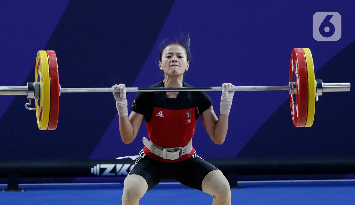 Lifter Windy Aisyah melakukan angkatan saat SEA Games 2019 cabang angkat besi nomor 49 kg di Stadion Rizal Memorial, Manila, Minggu (1/12/2019). Windy Aisyah meraih emas dengan total angkatan 104 kg. (Bola.com/M Iqbal Ichsan)