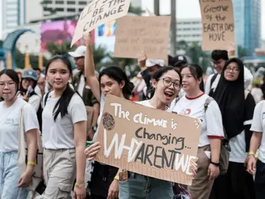 Para peserta memegang plakat saat mereka berbaris di jalan menjelang Hari Bumi pada 22 April, hari kesadaran lingkungan tahunan, di Jakarta pada 21 April 2024. (Yasuyoshi CHIBA/AFP)