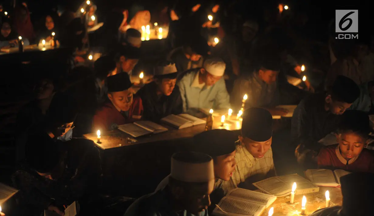 Santri dari Pondok Pesantren  Nurul Hidayah melakukan tadarus alquran dengan penerangan obor di tengah sawah Dusun Tempel, Desa Sempu, Kecamatan Andong, Kabupaten Boyolali, Selasa ( 21/5/2019). Pengajian tersebut untuk menyambut malam Nuzulul Quran pada 17 Ramadan 1440 Hijriah. (Liputan6.com/Gholib)