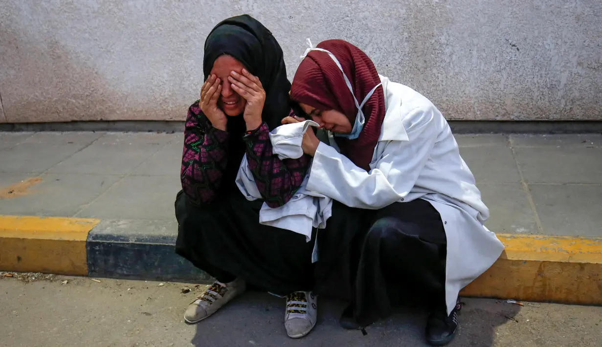 Perawat menangis atas kematian rekannya Razan al-Najjar di lorong rumah sakit Khan Yunis di Jalur Gaza selatan (1/6). Razan adalah sukarelawan Palestina berusia 21 tahun untuk kementerian kesehatan yang dikelola Hamas di Gaza. (AFP Photo/Kata Khatib)