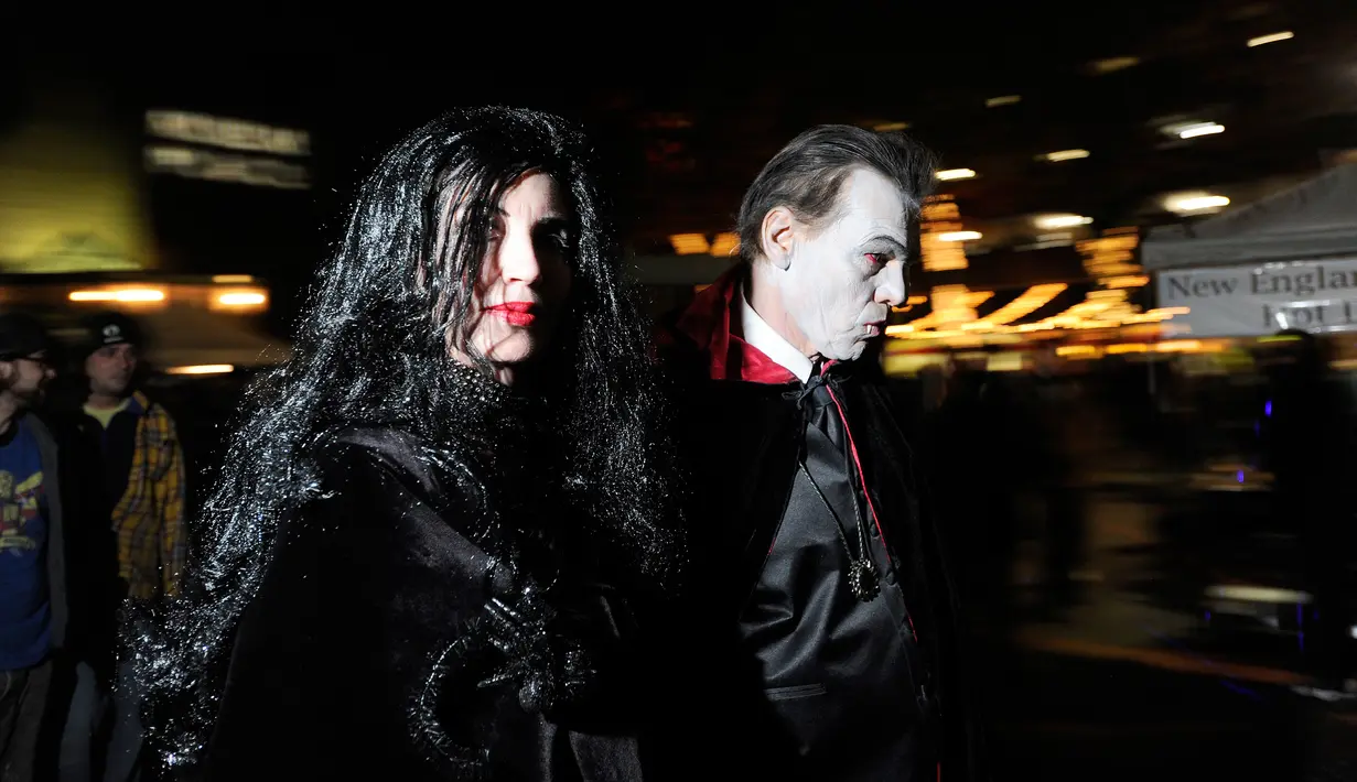 Sepasang warga mengenakan kostum vampir berkeliaran di jalanan saat perayaan Halloween di kota Salem, Massachusetts, AS, Rabu (31/10). Kota Salem juga dikenal sebagai Kota Penyihir karena memiliki banyak tempat yang menyeramkan. (Joseph PREZIOSO/AFP)