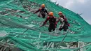 Para penyelamat membawa seekor anjing saat mereka menuruni penyangga yang roboh dari sebuah bangunan yang runtuh di kota Angeles, provinsi Pampanga, utara Manila, Filipina, Senin 25 Mei 2026. (AP Photo/Aaron Favila)