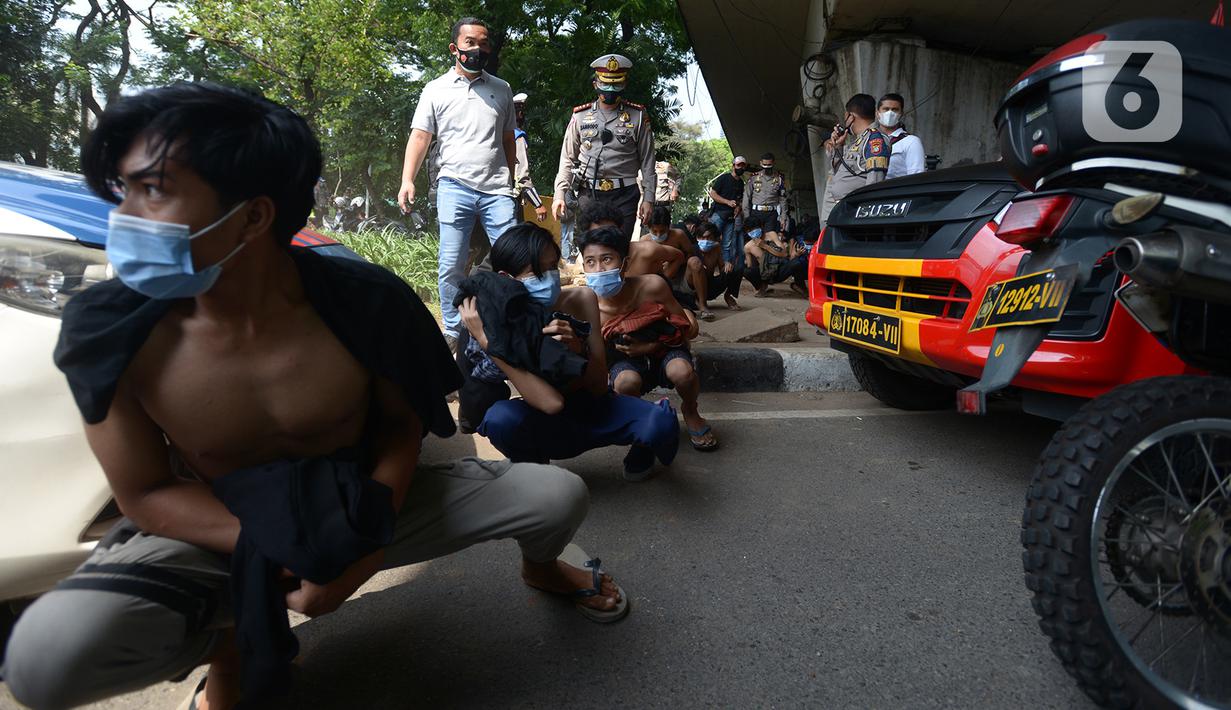 Sejumlah orang berjalan jongkok setelah diamankan petugas kepolisian di Kawasan Senayan, Jakarta, Kamis (8/10/2020). Mereka diduga hendak melakukan unjuk rasa di depan gedung DPR. (merdeka.com/Imam Buhori)