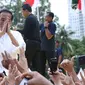 Capres nomor urut 01 Joko Widodo menyapa pendukungnya usai menghadiri Deklarasi Alumni UI untuk Jokowi-Amin di Plaza Tenggara GBK, Jakarta, Sabtu (12/1). Deklarasi dihadiri perwakilan alumni dari berbagai kampus. (Liputan6.com/Helmi Fithriansyah)