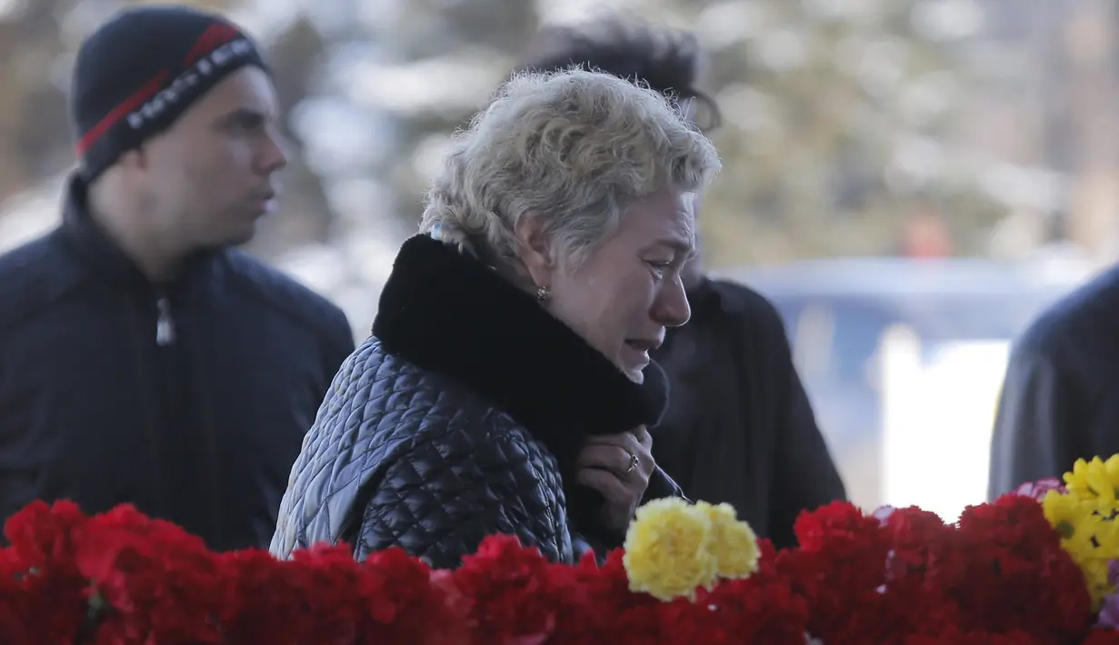 Seorang wanita menangis di dekat karangan bunga untuk korban jatuhnya pesawat maskapai Flydubai, di luar Bandara Rostov-on-Don, Rusia, Minggu (20/3). Insiden itu menewaskan seluruh penumpang dan kru yang berjumlah 62 orang. (REUTERS/Maxim Shemetov)