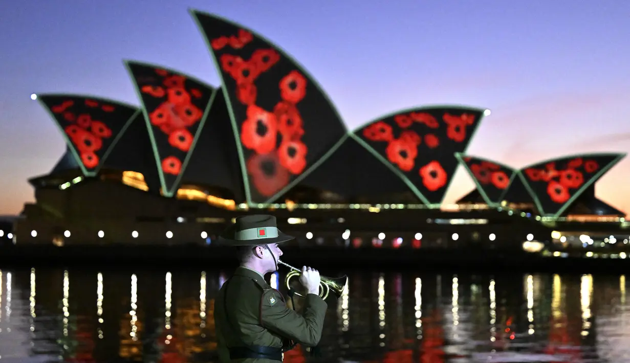 Bunga poppy diproyeksikan ke layar Opera House saat angkatan bersenjata Australia memainkan 'The Last Post' Remembrance Day Dawn Service di Sydney, Jumat (11/11/2022). Remembrance Day 2022 menandai 104 tahun sejak Gencatan Senjata yang mengakhiri Perang Dunia Pertama pada 11 November 1918. (Saeed KHAN / AFP)