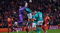 Virgil van Dijk dari Liverpool, kanan atas, dan kiper Galatasaray Ugurcan Cakir berebut bola tinggi saat pertandingan leg pertama babak 16 besar Liga Champions antara Galatasaray dan Liverpool, di Istanbul, Turki, Rabu (11-3-2026) dini hari WIB. (AP Photo/Khalil Hamra)