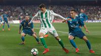 Pemain Real, Madrid Lucas Vazquez dan pemain Real Betis, Tello Herrea berebut bola pada laga pekan ke-24 La Liga Spanyol di Estadio Benito Villamarin, Minggu (18/2). Melalui pertarungan sengit 8 gol, Real Madrid menang 5-3. (AP/Miguel Morenatti)