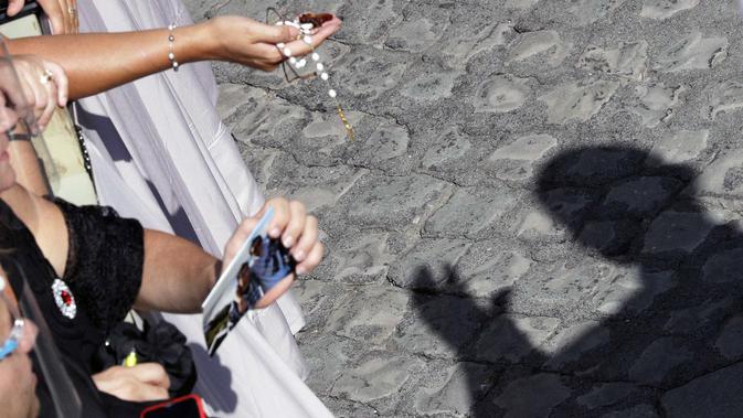 Bayangan Paus Fransiskus terlihat di tanah saat dia memberkati umat beriman di halaman St. Damaso pada kesempatan audiensi umum mingguan di Vatikan, Rabu, (16/9/2020). (AP Photo/Gregorio Borgia)