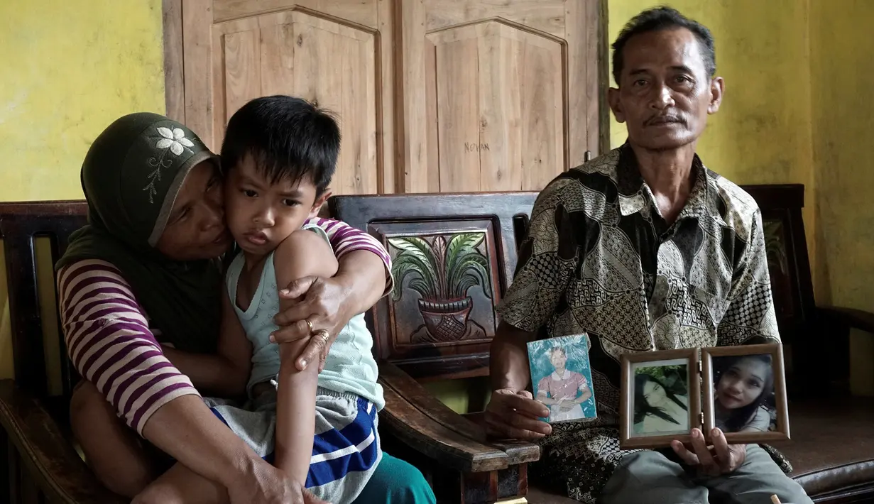 Muhamad Hafis Arnovan, putra Sumarti Ningsih dipangku neneknya saat menunggu kabar dari pengadilan Hong Kong di Cilacap, Indonesia (8/11). Orang tua Sumarti Ningsih berharap pembunuh anaknya diharuskan membiayai anak Sumarti. (REUTERS/Idhad Zakaria)