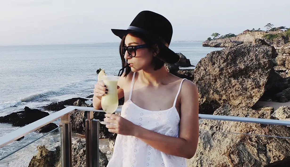 Saat pergi tamasya, istri Benjamin Pandelaki ini tampil santai dengan tanktop berwarna putih. Penampilannya terlihat standout dengan topi fedora berwarna hitam serta kacamata gelap. (Liputan6.com/IG/lolitagustine)