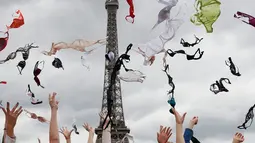 Puluhan wanita melemparkan bra mereka ke udara saat mengikuti acara tahunan "Pink Bra Toss" di depan Menara Eiffel, Paris, Minggu (13/5). Aksi yang diselenggarakan Pink Bazaar ini untuk meningkatkan kesadaran mengenai kanker payudara. (AP/Christophe Ena)
