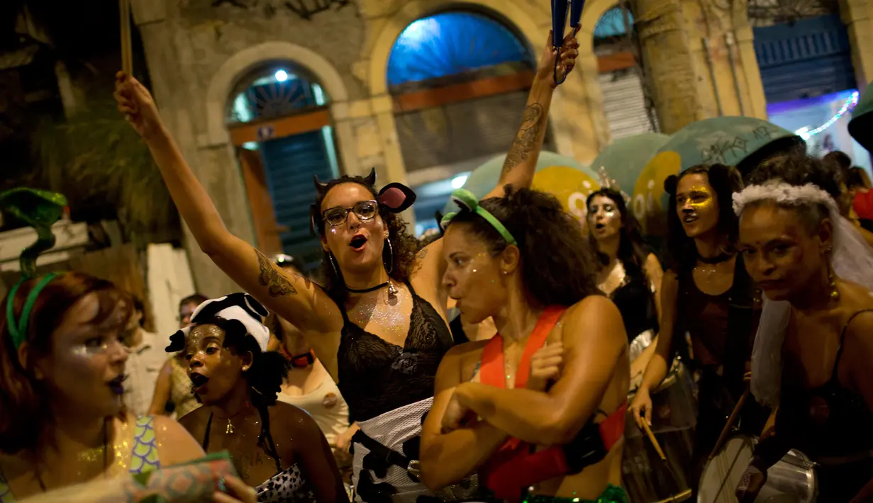 Sejumlah wanita memainkan musik sambil menari turun ke jalan untuk merayakan karnaval "Maria vem com as outras" di Rio de Janeiro, Brasil (3/2). (AP Photo / Silvia Izquierdo)
